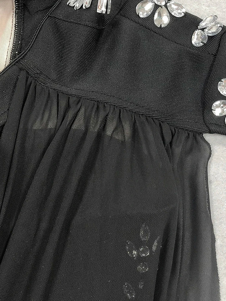 Rhinestone Bodysuit met Cape met strassversieringen en vloeiende stofdetails.