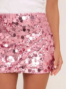 Pink sequin bodycon mini skirt, shimmering with all-over round sequins, worn by a model.