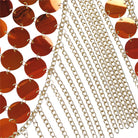 Close-up of shimmering orange sequins and gold chains for festival wear, enhancing the Festival Top and Tassel Mini Skirt Set.