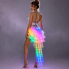 Model wearing a tiered white tulle LED long skirt with vibrant, multi-colored glowing lights and a high-low silhouette.