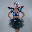 Model wearing a futuristic black LED tutu bra set with glowing shoulder pieces, a light-up bodice, and a matching tulle skirt.