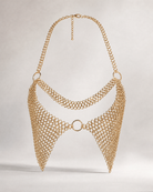 Gold metal chain bra with intricate interlocking rings, halter neck, and central ring detail.