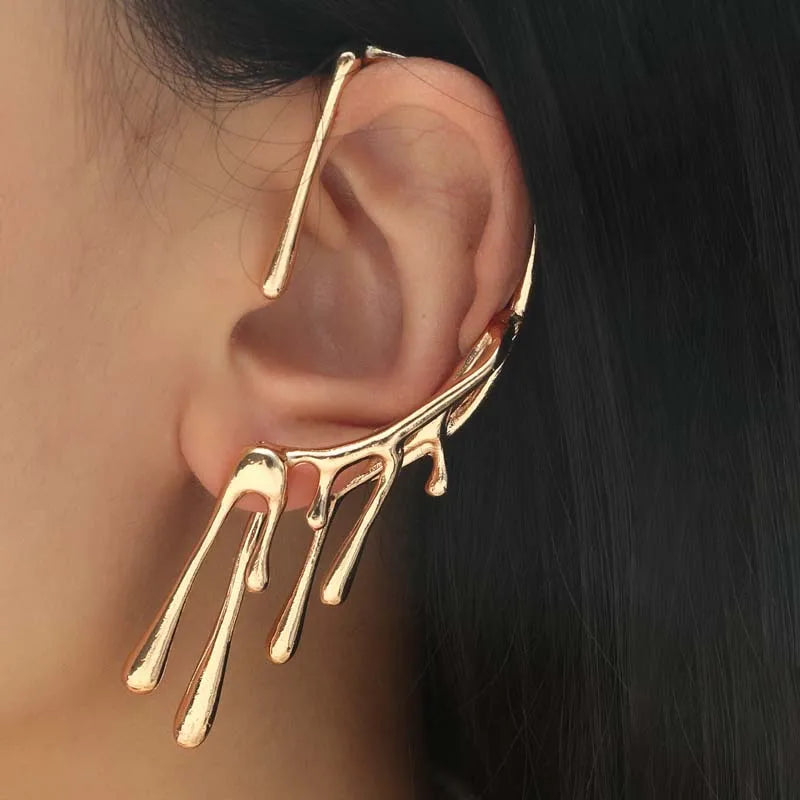 Gold-toned full ear cuff with a dripping liquid metal design, worn on a left ear.