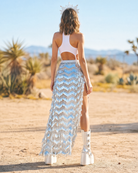 Silver sequin maxi skirt with a chevron pattern and high slit, styled with white platform boots.