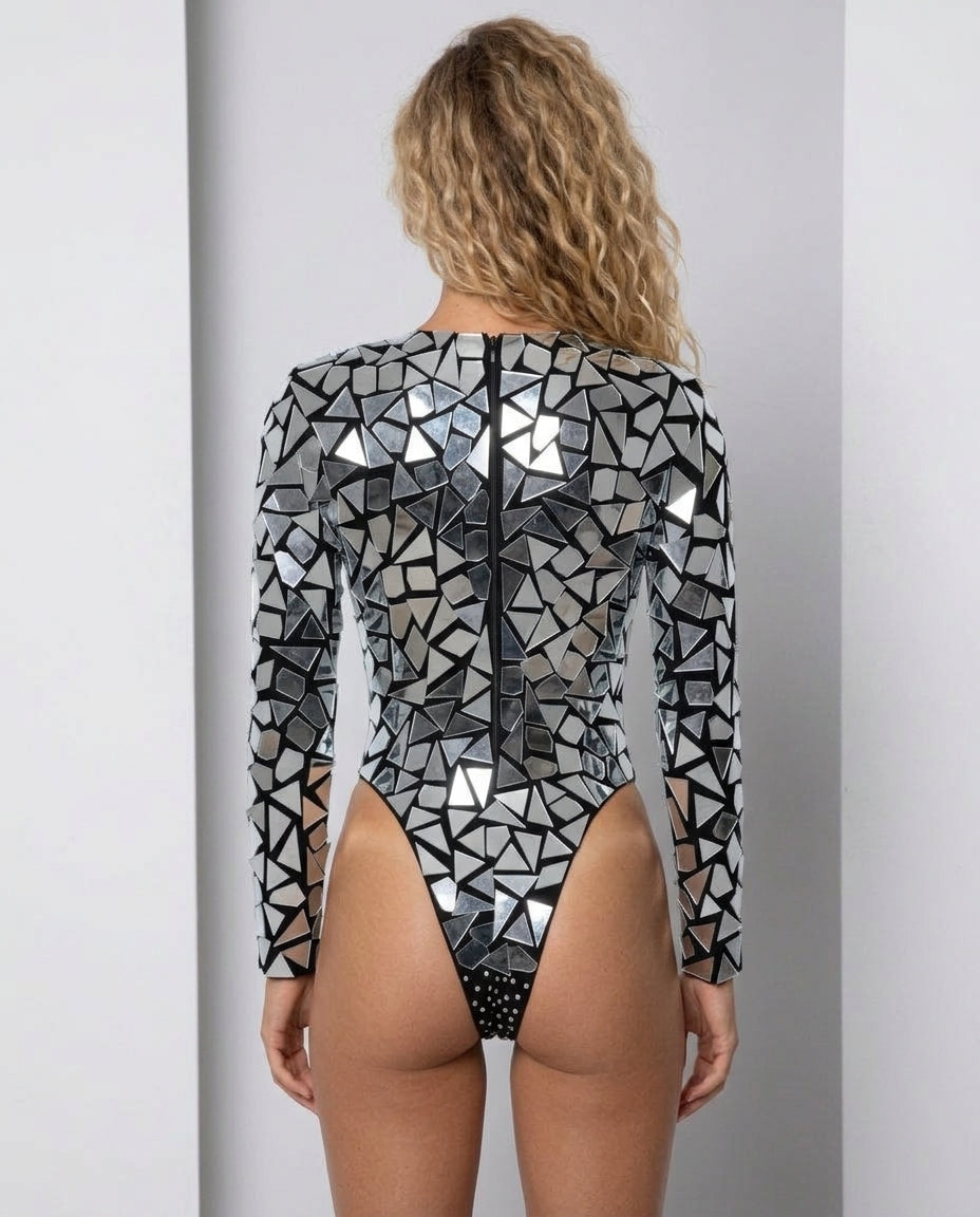 Kayla Mirror Rhinestone Bodysuit, a long-sleeved, high-cut silver bodysuit with reflective mirror pieces and a back zipper.
