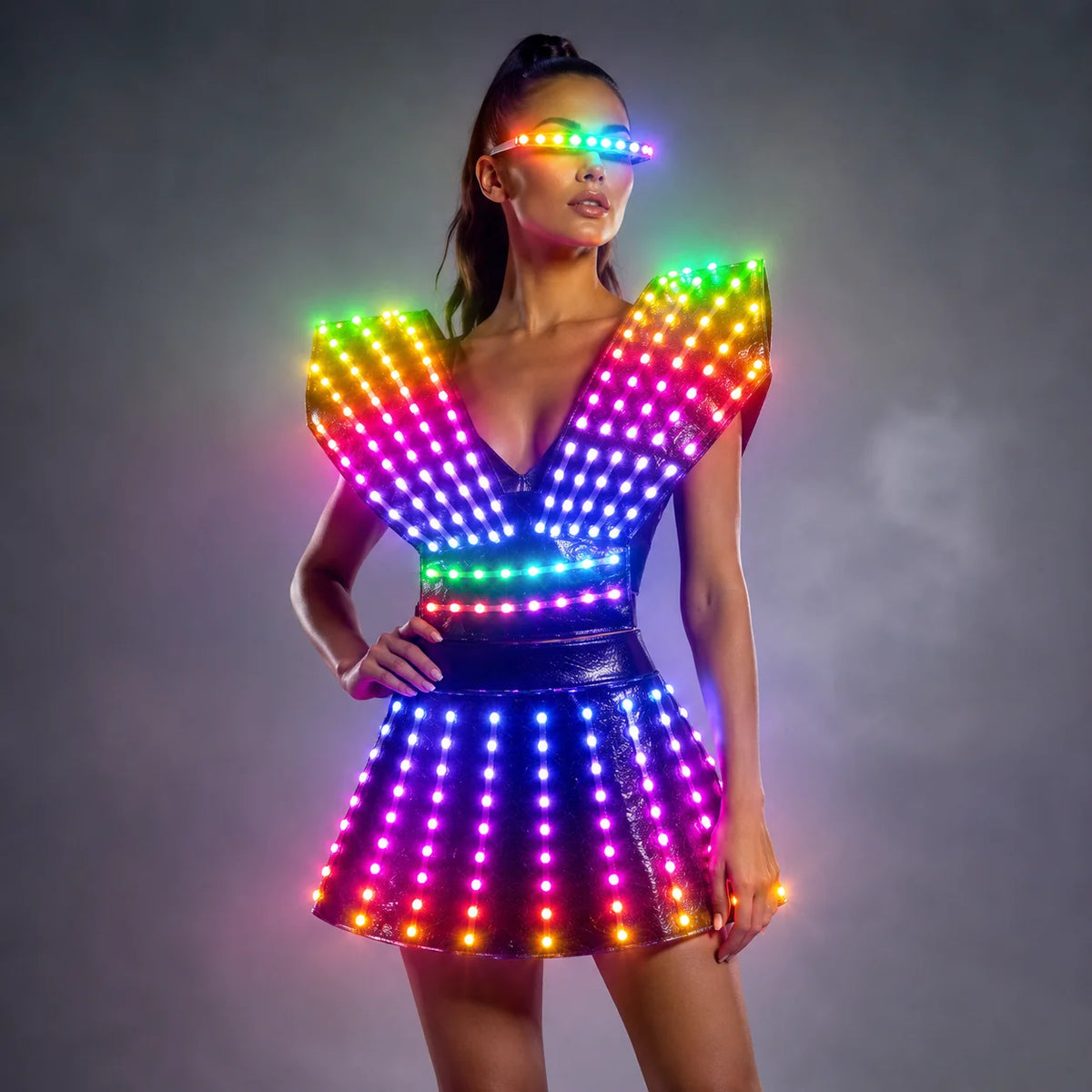 Model wearing a futuristic black LED dress with glowing rainbow lights and matching light-up visor for stage performances.