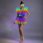 Model wearing a futuristic LED dress with rainbow glowing lights, structured shoulders, and matching light-up visor.
