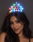 Woman wearing a silver rhinestone tiara featuring glowing multicolored LED lights against a dark background.