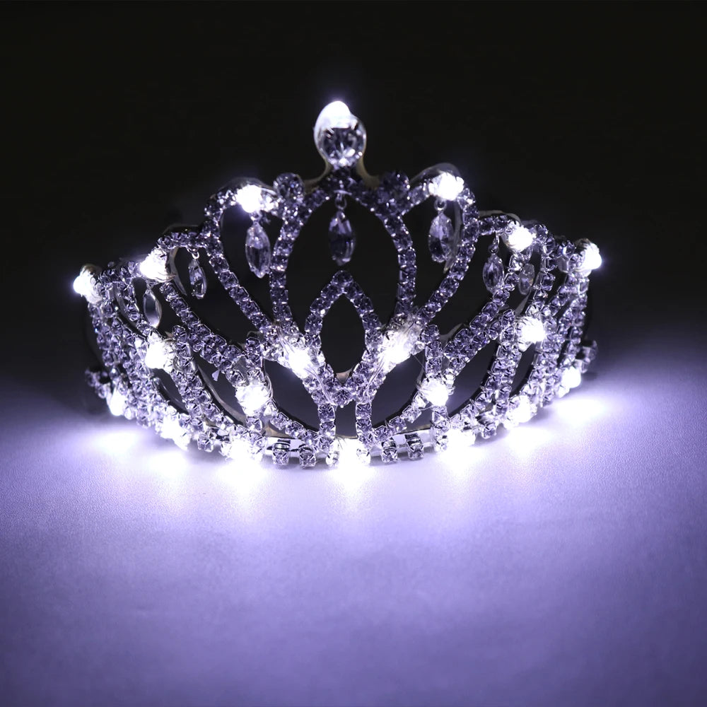 Glowing rhinestone tiara featuring intricate silver filigree and bright white LED lights against a dark background.