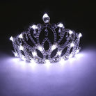 Glowing rhinestone tiara featuring intricate silver filigree and bright white LED lights against a dark background.