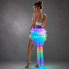 Model wearing a layered tulle LED tutu skirt with multi-colored glowing lights and a sparkling purple waistband.
