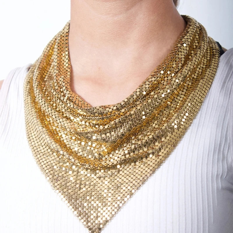 Gold liquid metal mesh scarf draped in a triangular bib style over a white top.