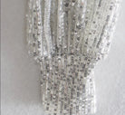Top de manga larga con lentejuelas plateadas brillantes y detalle fruncido en la muñeca para un look glamuroso.