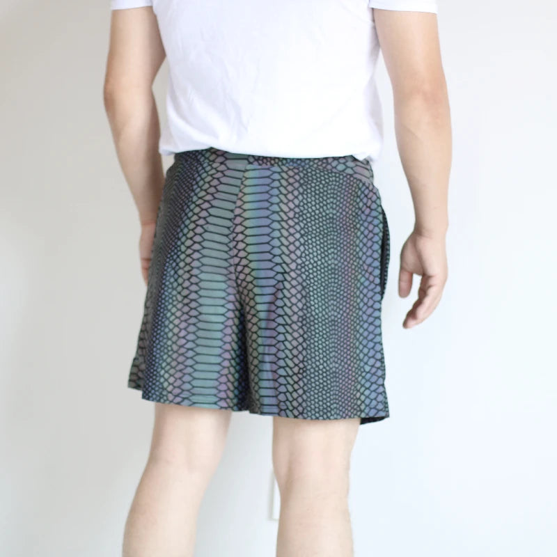 Men's reflective festival shorts with a snakeskin pattern, shown on a model from behind.