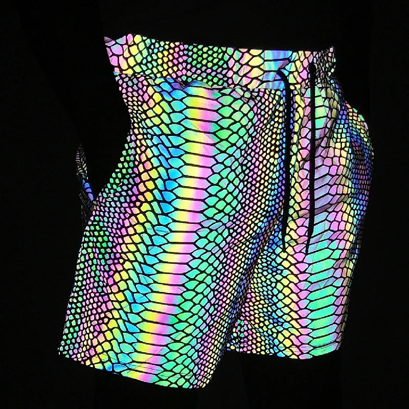 Men's reflective festival shorts with a vibrant, iridescent snakeskin pattern and drawstring waist.