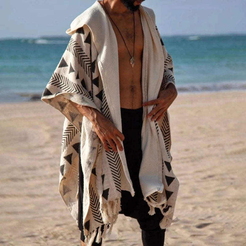 Men's Tulum Fringe Cardigan: beige polyester with black geometric patterns and fringe hem, worn open on a beach.