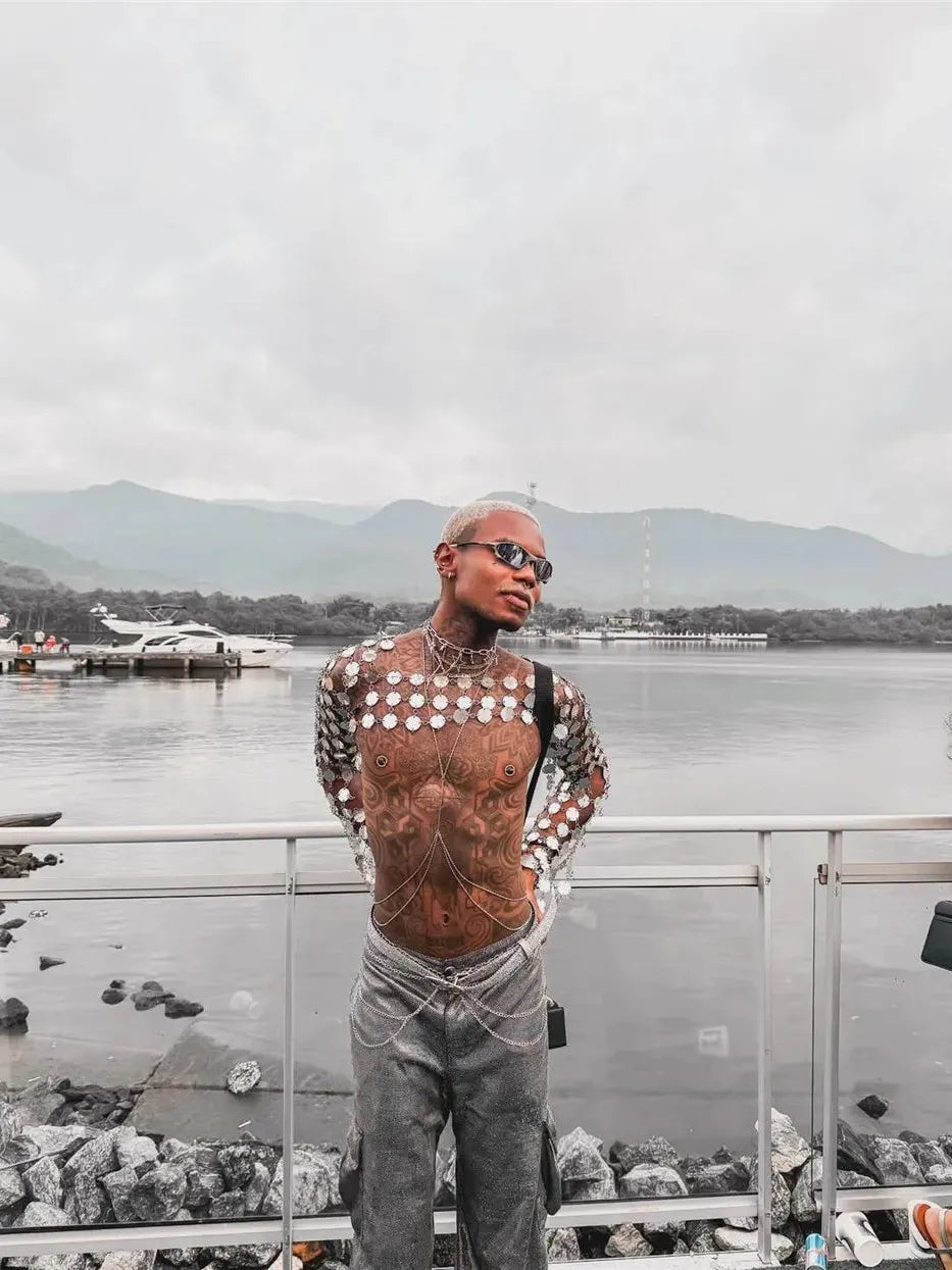 metal chain disc crop top side-profile with tattoos outdoors against water backdrop