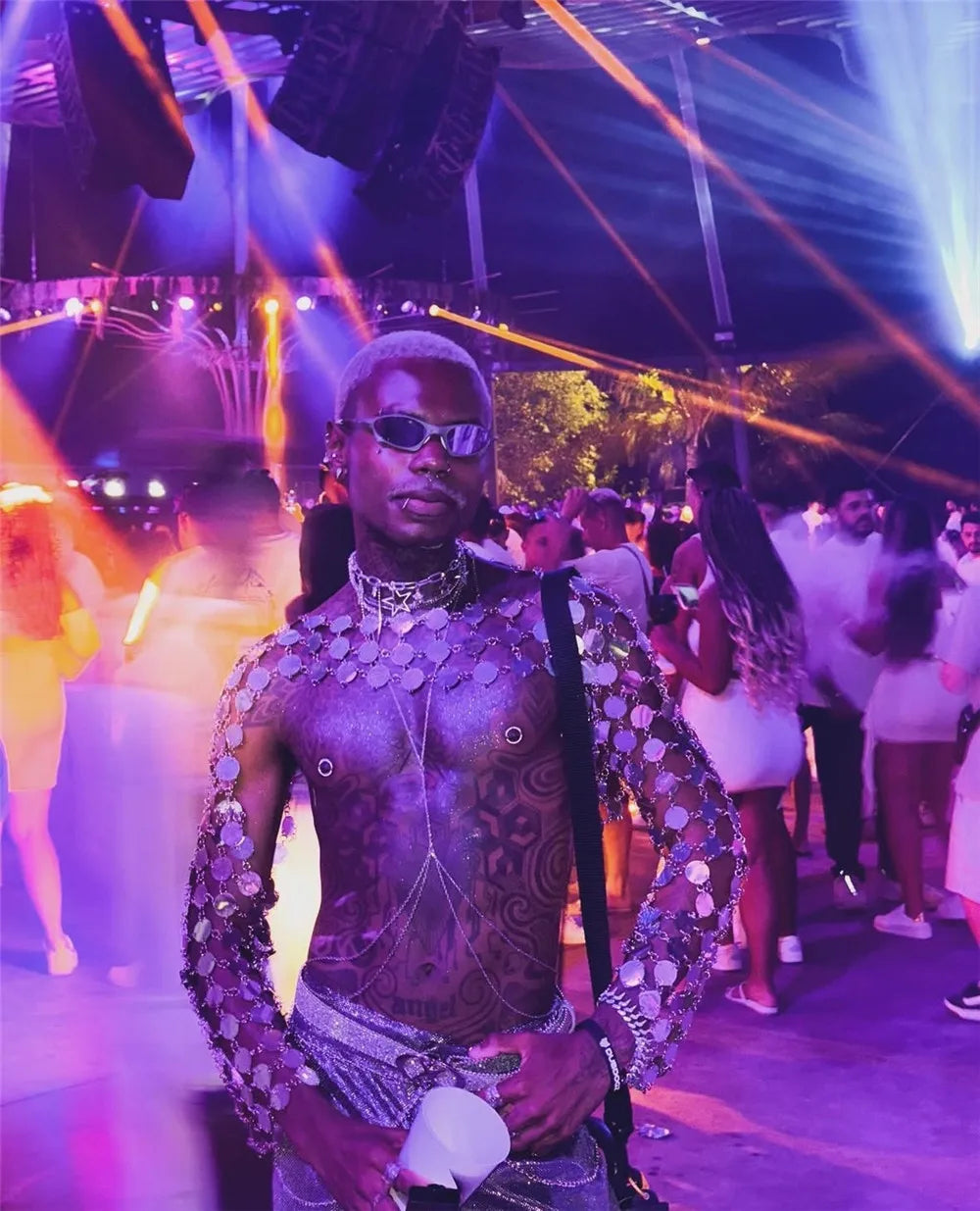 metal chain disc crop top close-up showing model in vibrant nightlife with disco lights