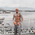 gros plan sur un haut court à disque en chaîne métallique, modèle posant près de l'eau avec des montagnes en arrière-plan