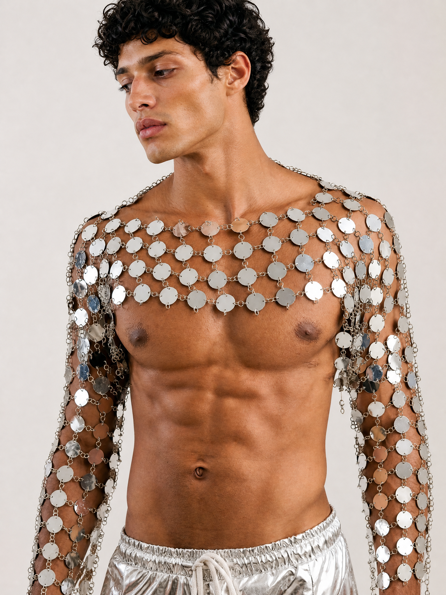 Silver metal chain crop top featuring interconnected circular discs in an armor-inspired design with long sleeves.