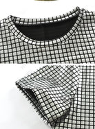 Gros plan sur le col et la manche d'un T-shirt métallique avec un motif carré brillant.