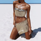 close-up of metallic top and skirt set in gold at the beach, showcasing festival-ready style