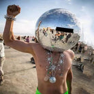 40cm Mirror Disco Ball Helmet made of ABS with hundreds of mirror panels, worn by a person outdoors.