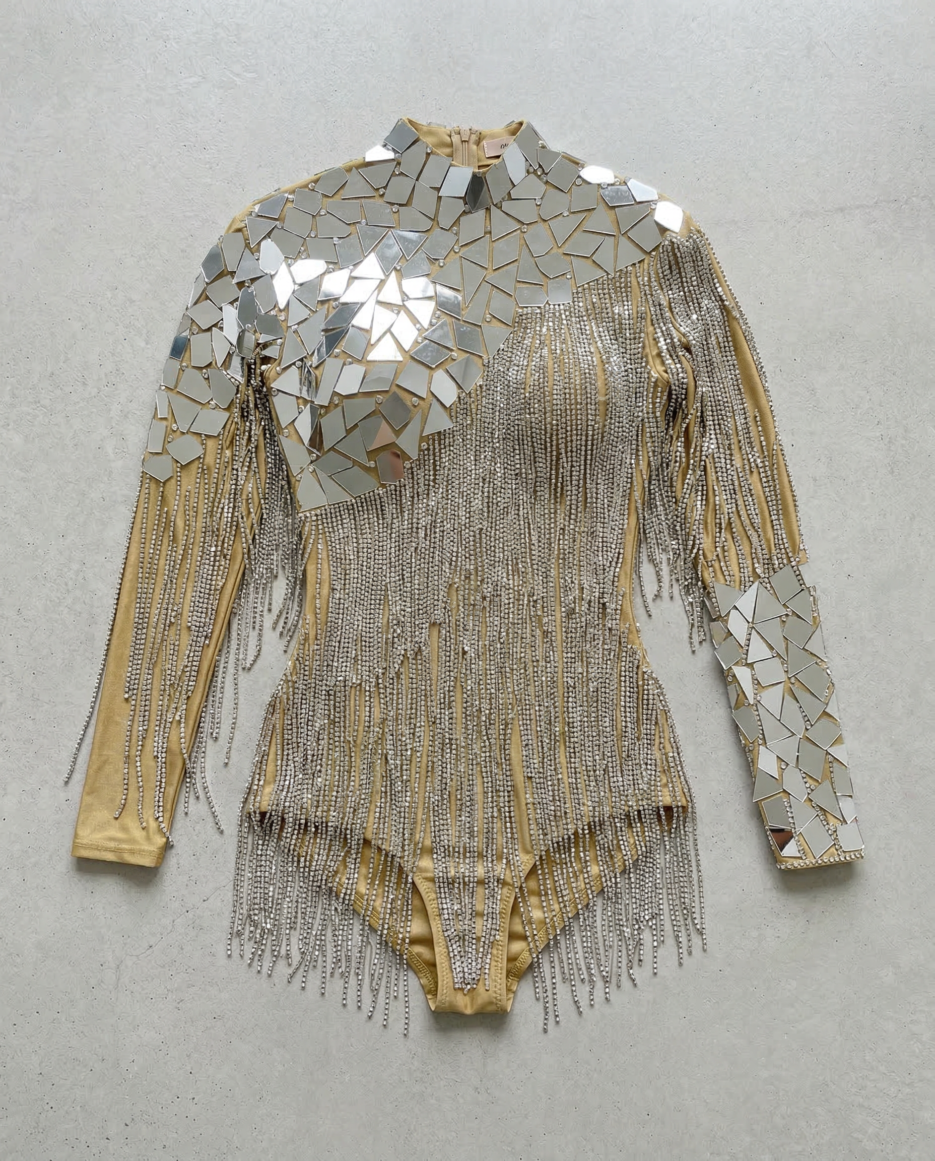 Gold backless bodysuit with mirror panels and cascading rhinestone chain fringe.