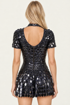 Back view of a black metallic sequin party dress with a turtleneck collar, short sleeves, and a back zipper closure.