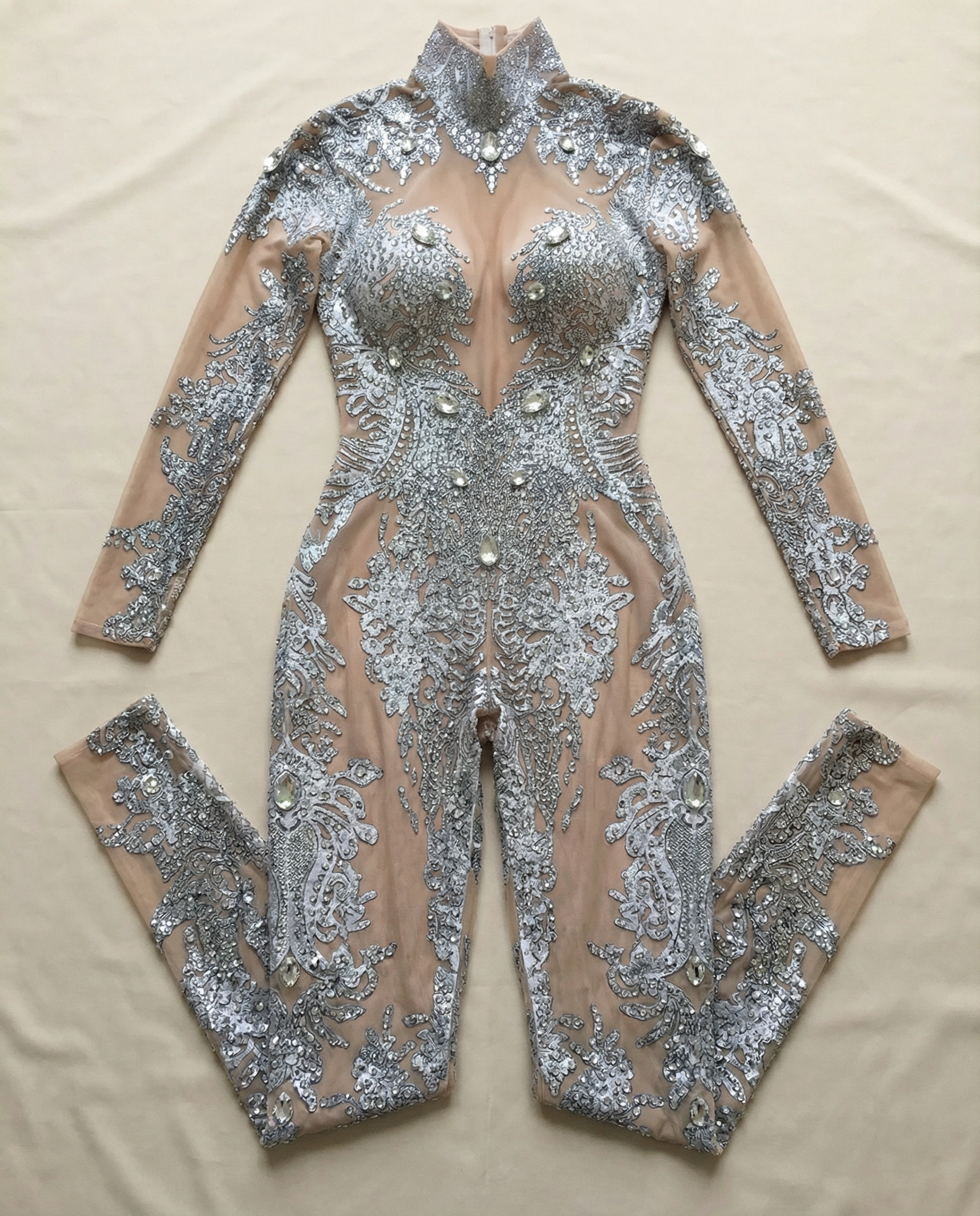 Silver rhinestone metallic jumpsuit with sheer nude mesh and intricate sparkling embellishments.