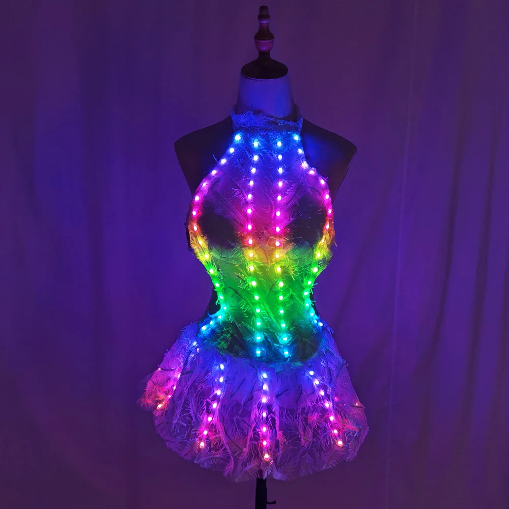 Futuristic white lace dress on a mannequin featuring vibrant, multi-colored LED light strips for a glowing effect.