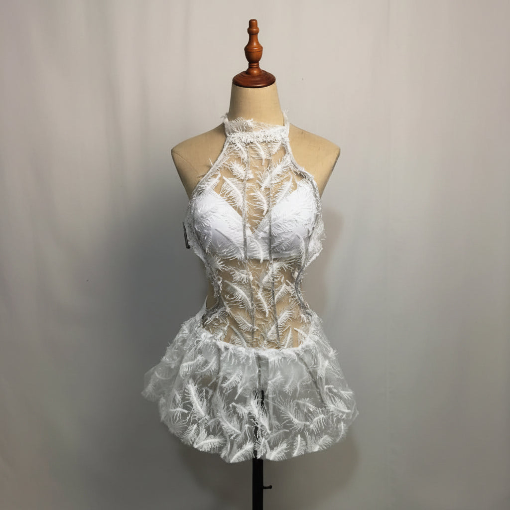 White futuristic LED dress featuring delicate lace, feather-like patterns, and a halter neckline on a mannequin.