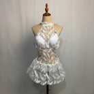 White futuristic LED dress featuring delicate lace, feather-like patterns, and a halter neckline on a mannequin.