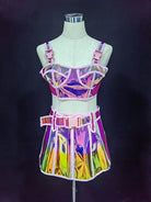 Pink reflective polyester crop top and mini skirt set with buckles and zipper, displayed on a mannequin.