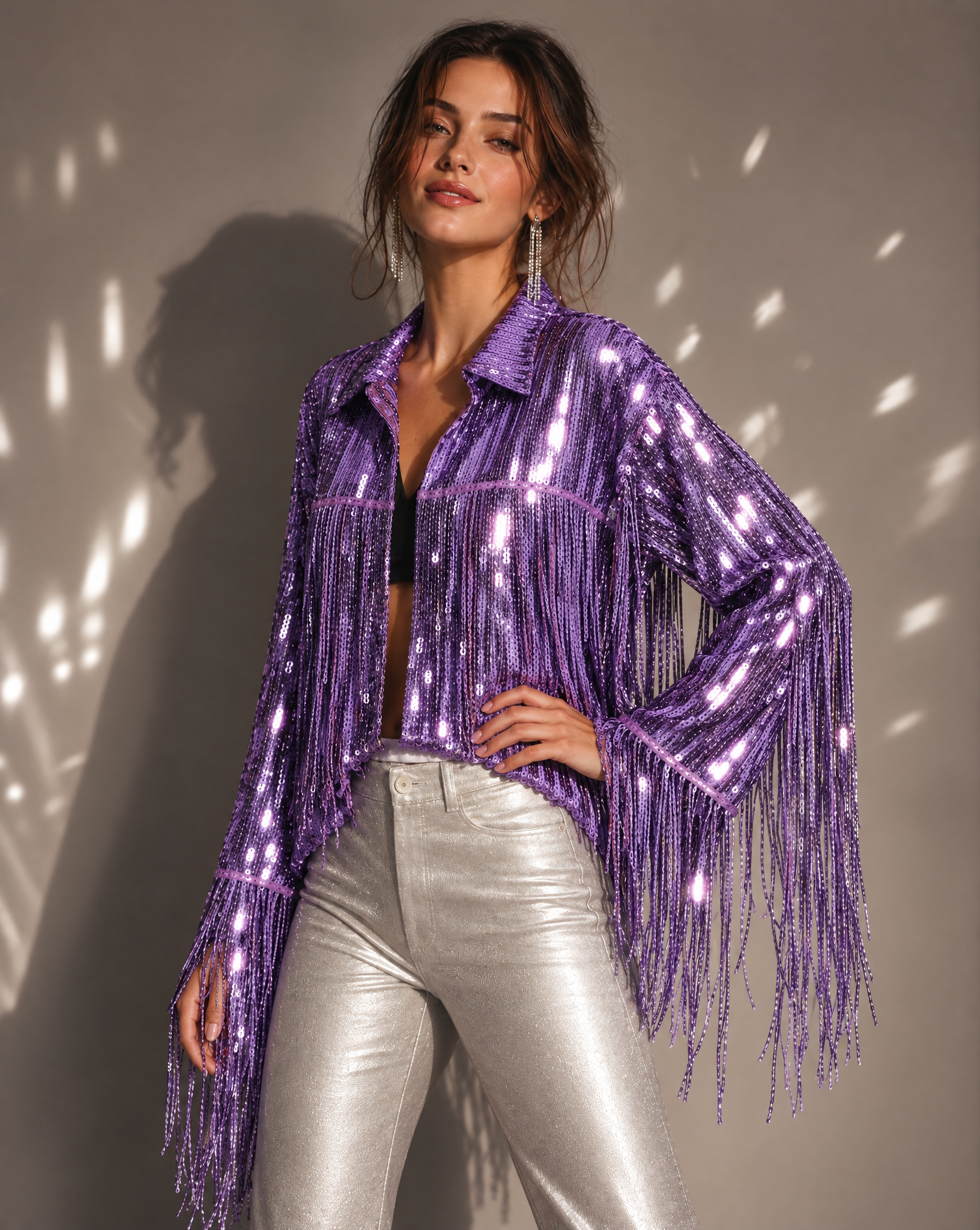 Model wearing a metallic purple sequin jacket with long fringe sleeves and a collar, paired with silver pants.