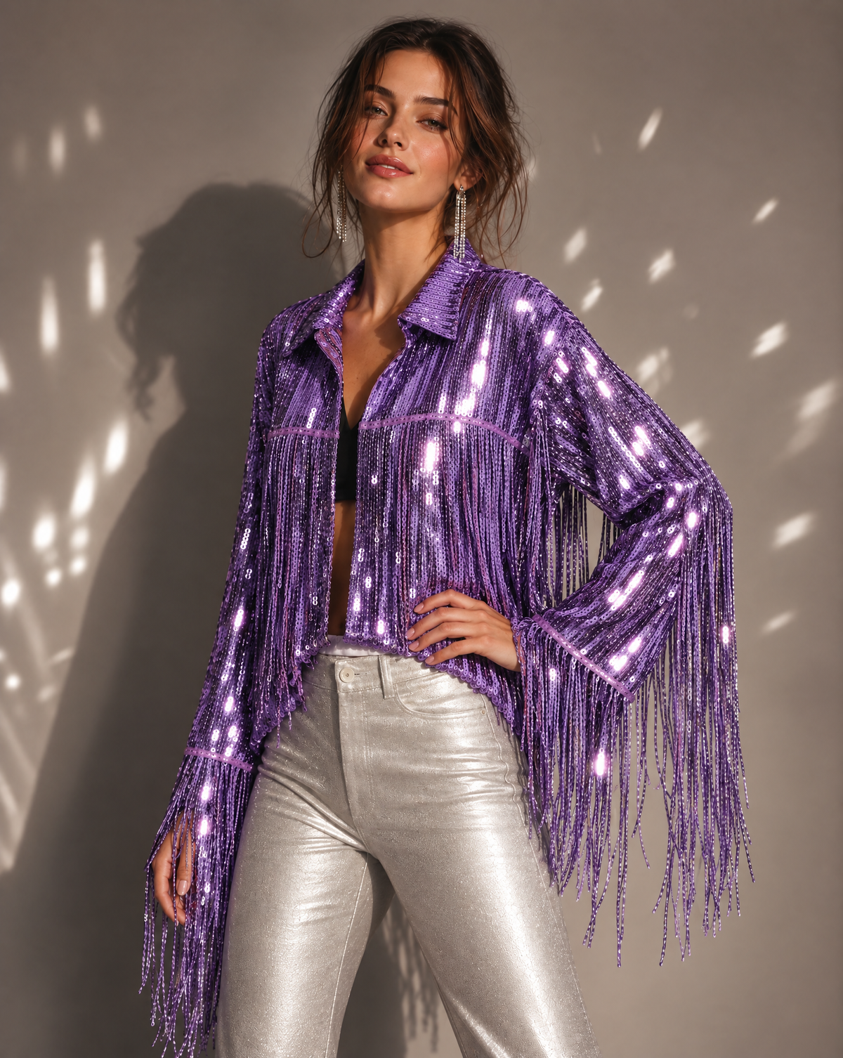 Model wearing a metallic purple sequin jacket with long fringe sleeves and a collar, paired with silver pants.