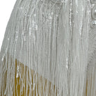 close-up of white tassel pearl sequin fringe bodysuit shimmering details and fringes
