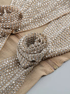 Detalle de los adornos de pedrería en el conjunto de fiesta con top y falda con recortes de flores de pedrería.