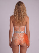 Back view of a sleeveless orange bodysuit with sheer tulle, hand-glued rhinestones, and a concealed back zipper.