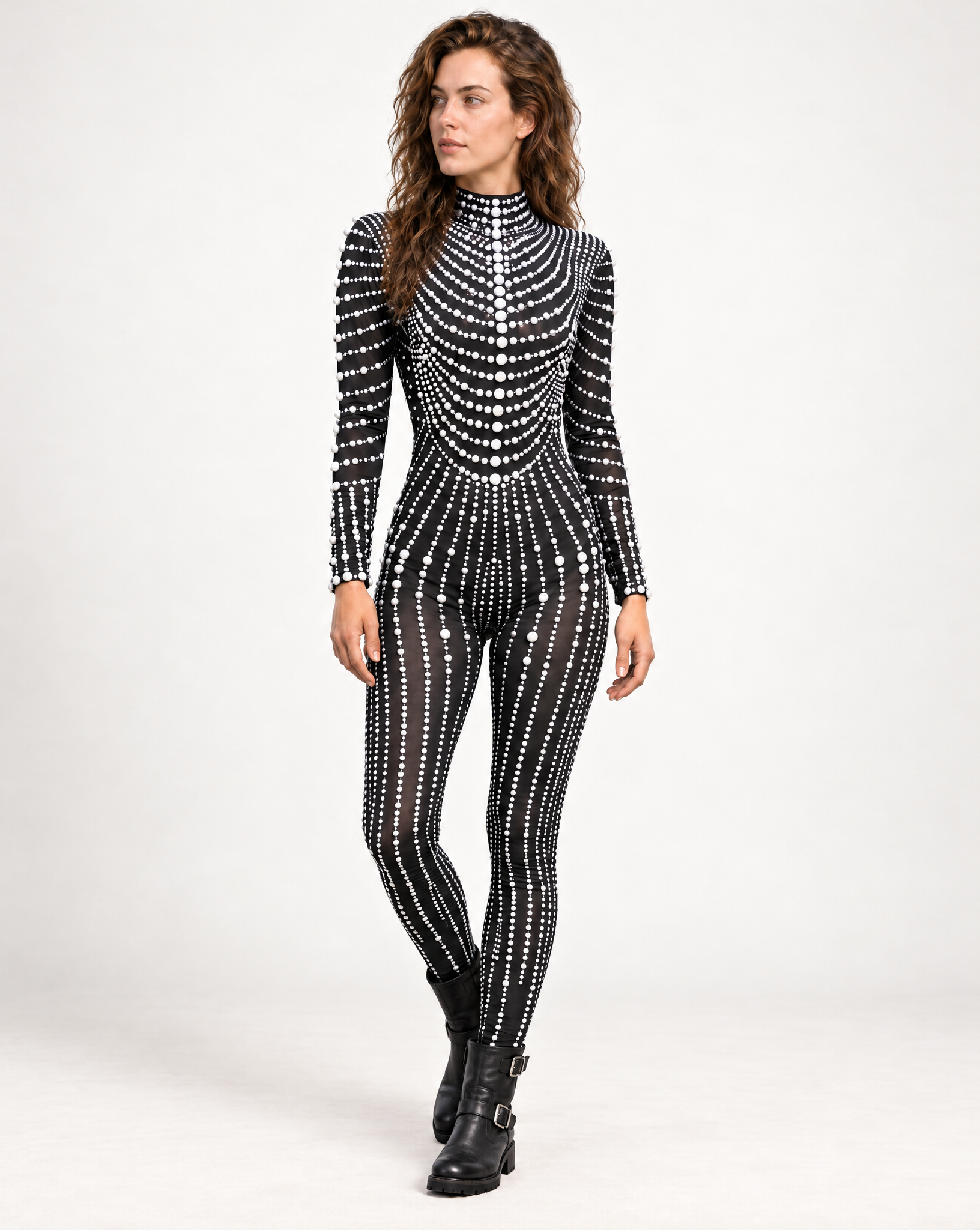 Model wearing a black long-sleeve jumpsuit adorned with intricate white pearl patterns and a high neckline.