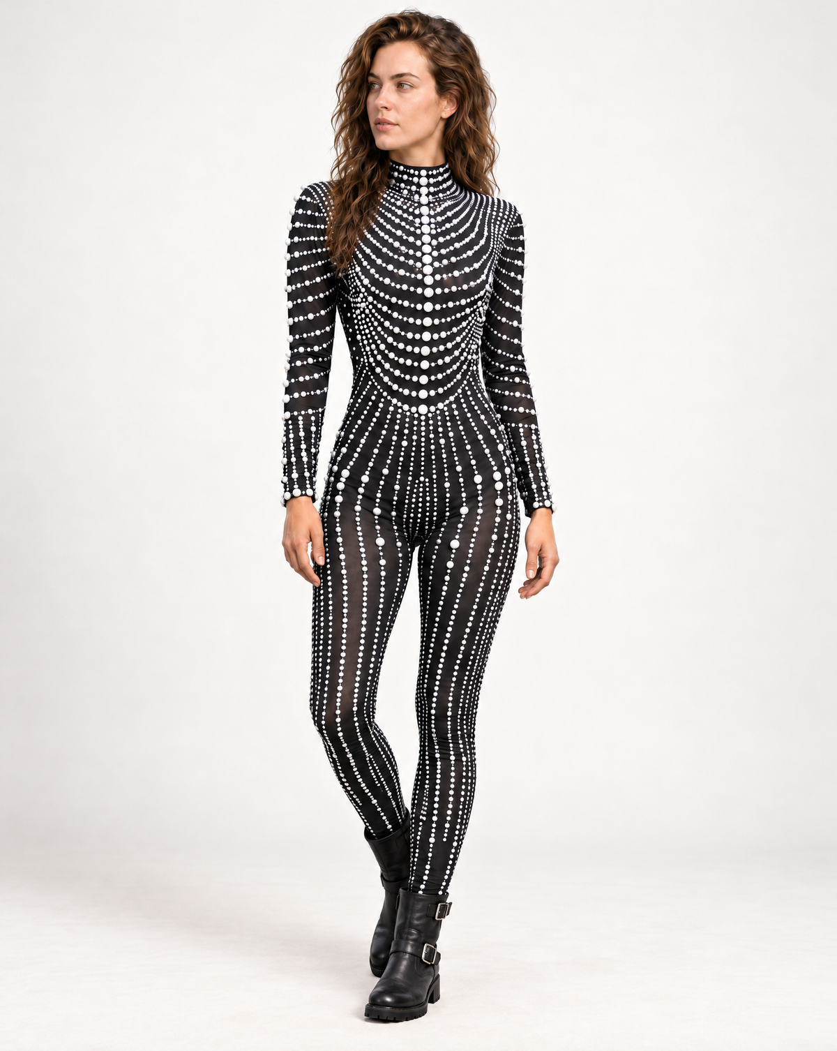 Model wearing a black long-sleeve jumpsuit adorned with intricate white pearl patterns and a high neckline.