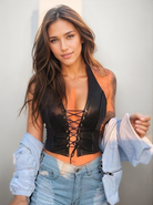 Femme portant un crop top en cuir élégant et audacieux avec un devant lacé, présentant une tenue de festival tendance.
