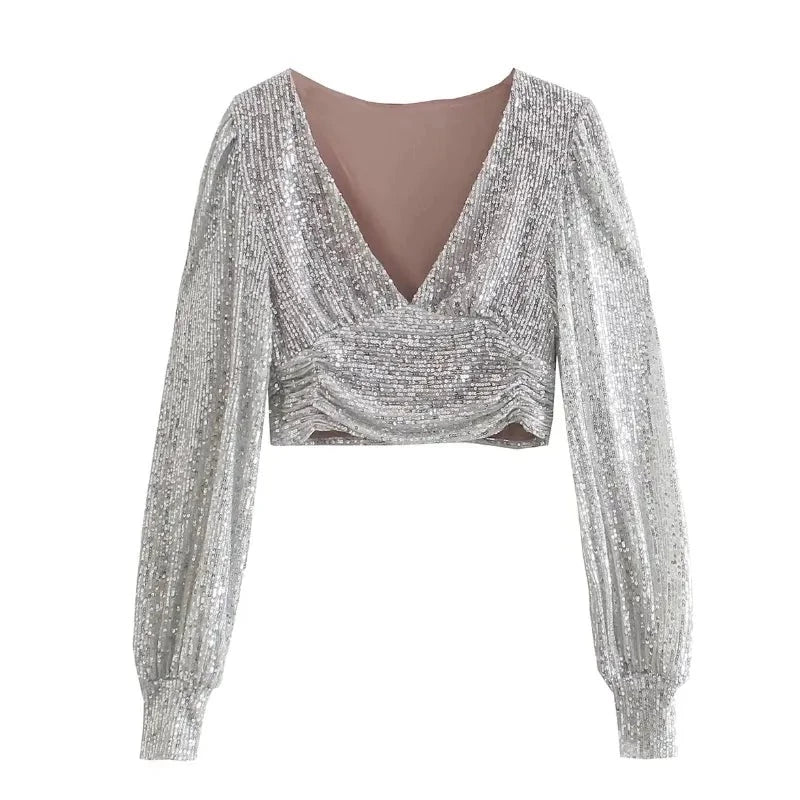 Long Sleeve Sequin Top featuring a shimmery silver design with a plunging neckline and stylish long sleeves.