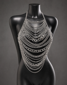 Silver sequin metal chest piece with layered chains on a black mannequin.
