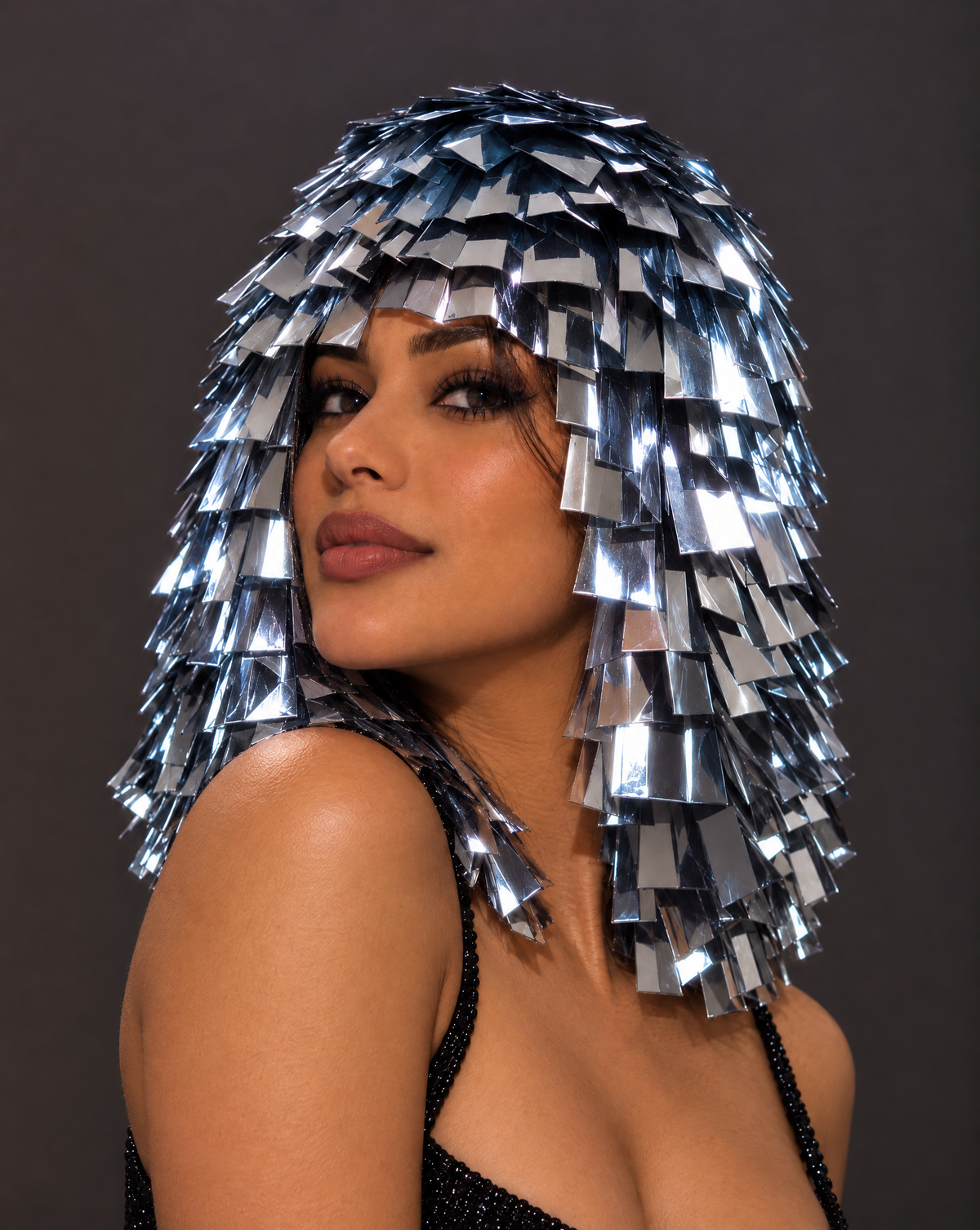 Model wearing a metallic silver fringe wig with reflective sequin panels for a futuristic festival look.