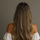 Silver rhinestone fringe chain headband on long wavy brown hair, viewed from behind.