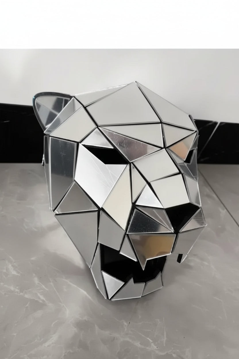 Máscara de tigre geométrica plateada con espejo, hecha de paneles de acrílico cortados con precisión, que reflejan la luz.