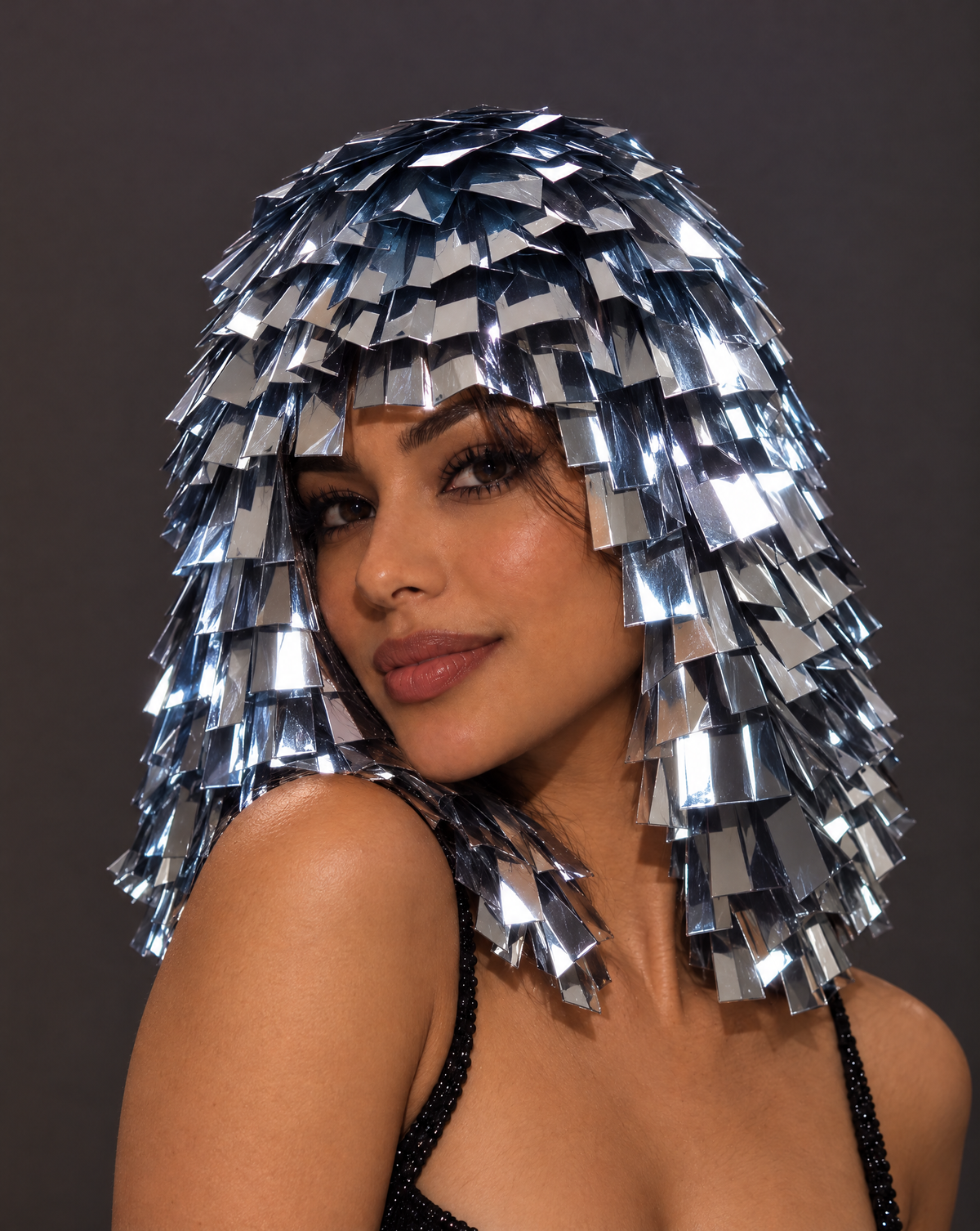 Model wearing a metallic silver fringe wig with reflective sequin panels for a futuristic festival look.