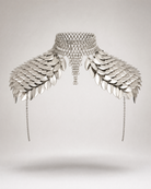 Silver metal shoulder armor body jewelry with overlapping scales, chainmail choker, and draped side chains.