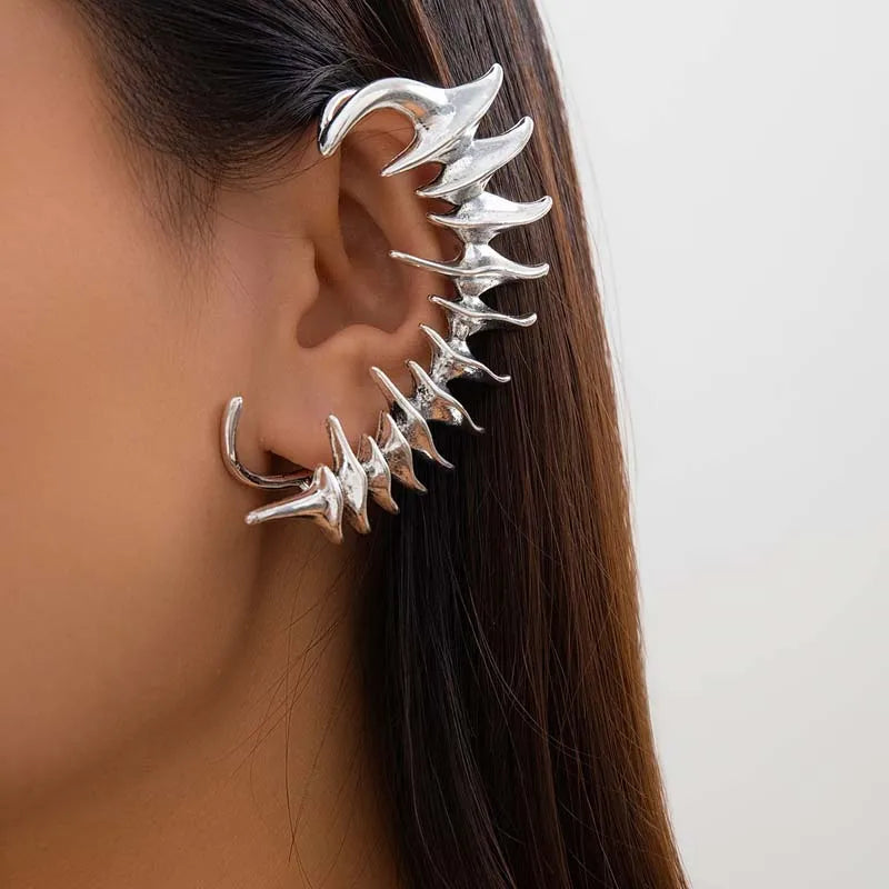 Ear Cuff Cyberpunk in metallo argento, un avvolgimento completo per l'orecchio con punte angolari affilate in un design a colonna vertebrale biomeccanica.